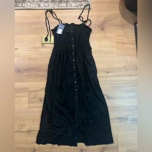 Simple black dress with buttons down front, adjustable straps and a stretch top
